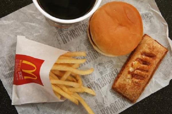 flawed mcdonald  s burger in front of desi snacks