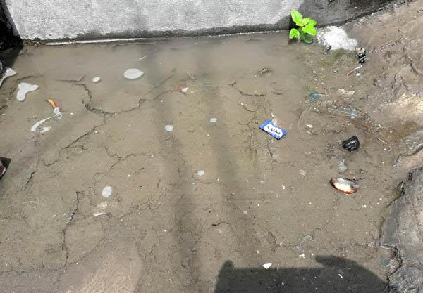 people in green field surrounded by sewerage difficulties