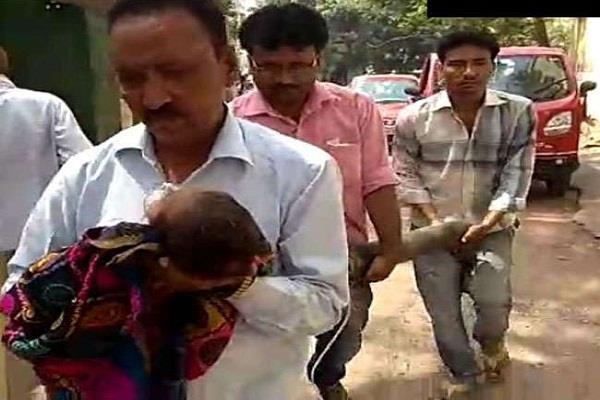 the sick child in the lap and the oxygen cylinder in the hand