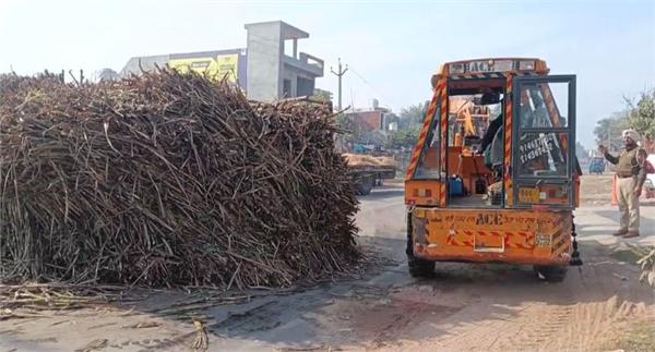 a trolley full of sugarcane overturned on the road due to loss of balance