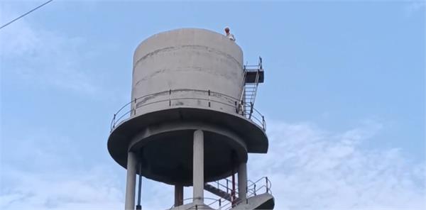 elderly man climbed on water tank