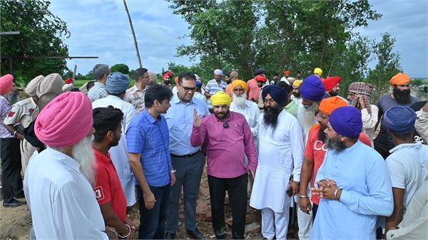cabinet minister eto helps villagers fill a hole caused by a landslide
