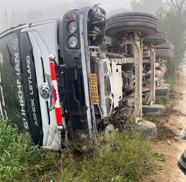 truck loaded with gravel overturns in field
