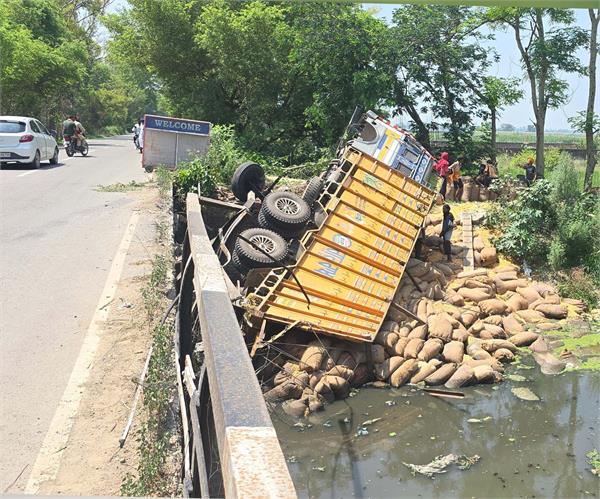 truck loaded with corn falls into drain