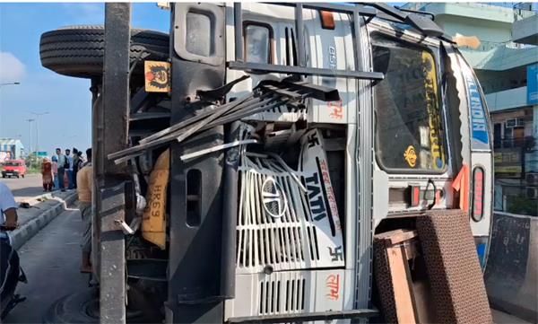 a truck full of cardboard boxes overturned on a bridge
